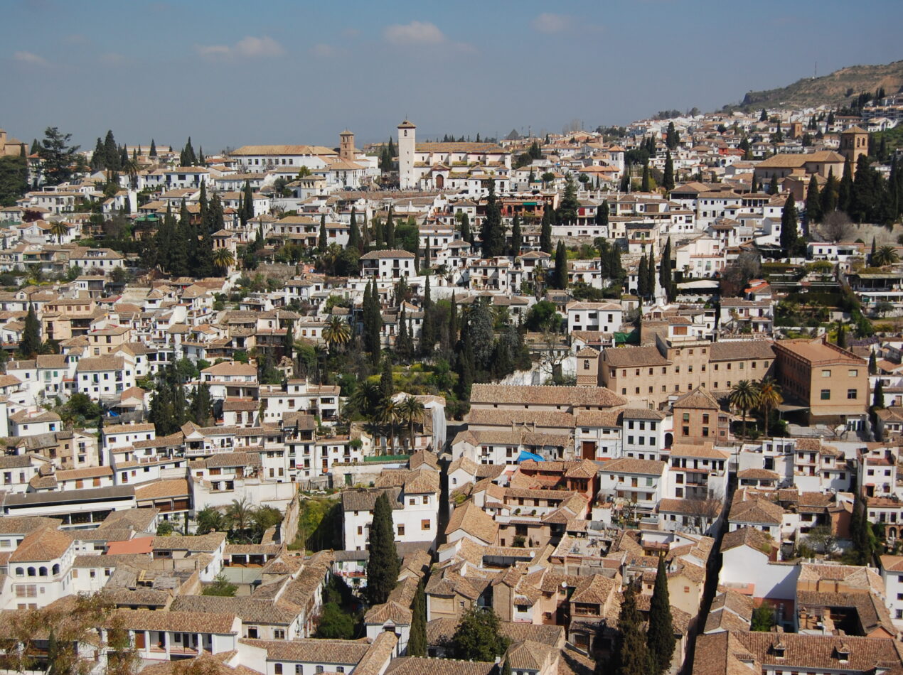 Panorámica del barrio del Albaicín en Granada destacando la densidad de cubiertas de teja árabe y el paisaje urbano protegido.