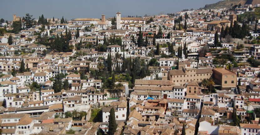 Panorámica del barrio del Albaicín en Granada destacando la densidad de cubiertas de teja árabe y el paisaje urbano protegido.