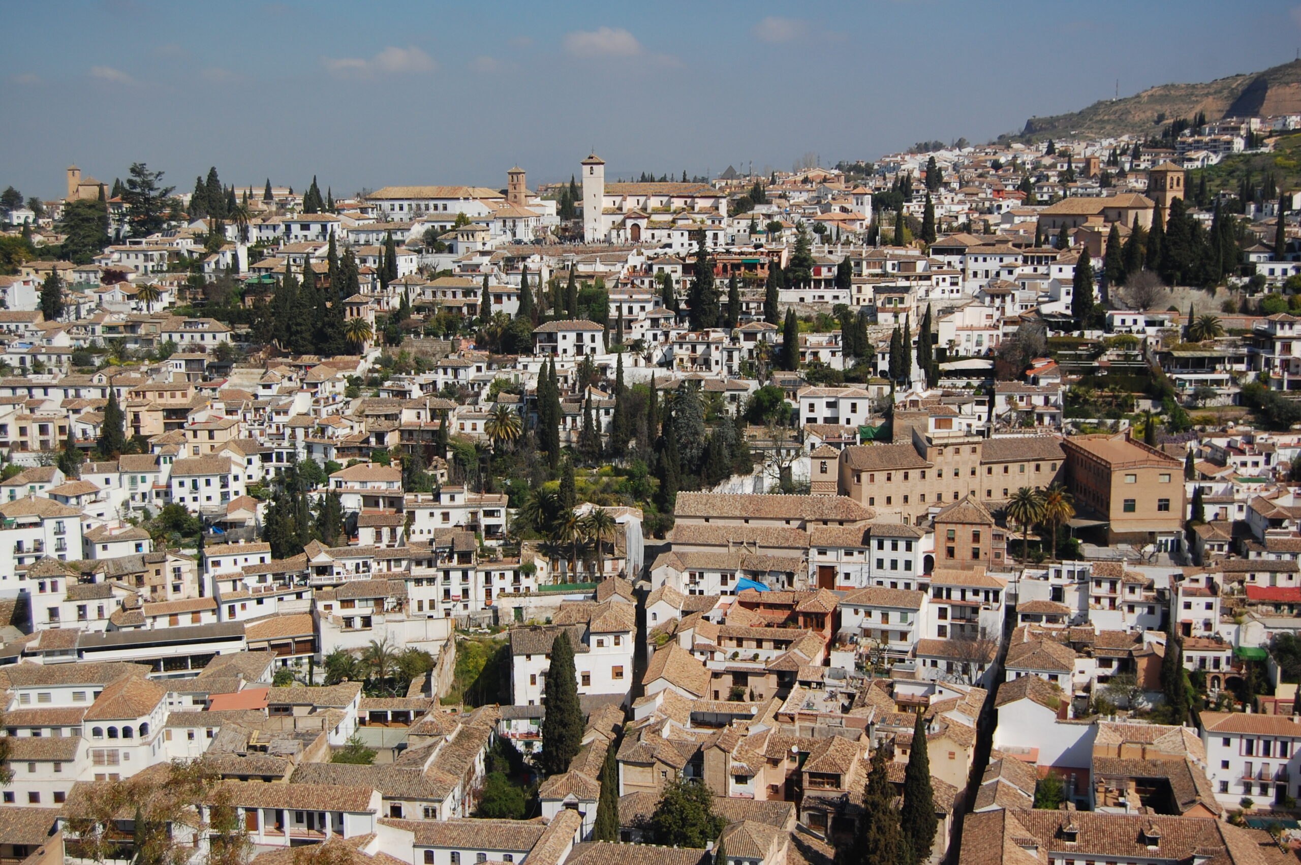 Panorámica del barrio del Albaicín en Granada destacando la densidad de cubiertas de teja árabe y el paisaje urbano protegido.